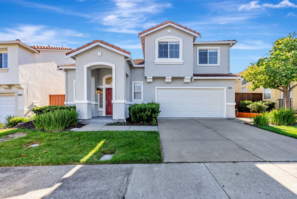 A two-story stucco home with arched entry, professionally managed by Bay Vista PM.