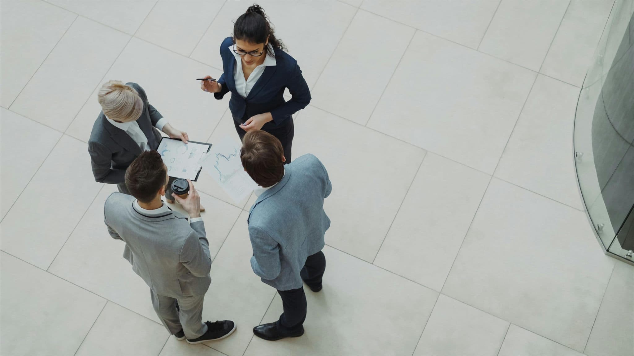 Overhead view of professionals at a business meeting reviewing documents.